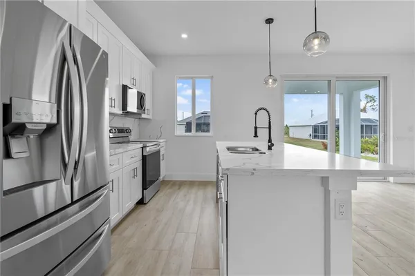 a kitchen with stainless steel appliances a sink cabinets and wooden floor