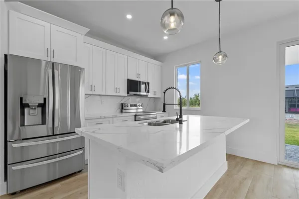 a kitchen with stainless steel appliances a refrigerator sink and microwave