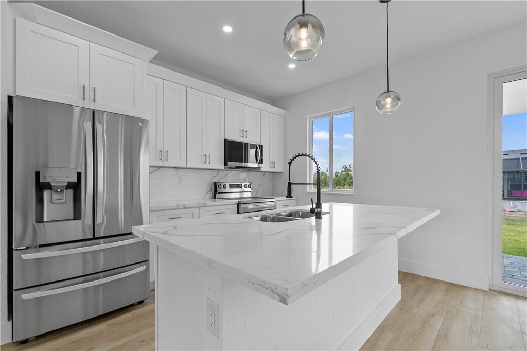 13438 Mc Intosh Avenue Port Charlotte, FL 33981 - Photo 12 of 46 a kitchen with stainless steel appliances a refrigerator sink and microwave