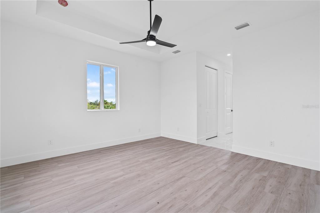 13438 Mc Intosh Avenue Port Charlotte, FL 33981 - Photo 18 of 46 wooden floor in an empty room with a window