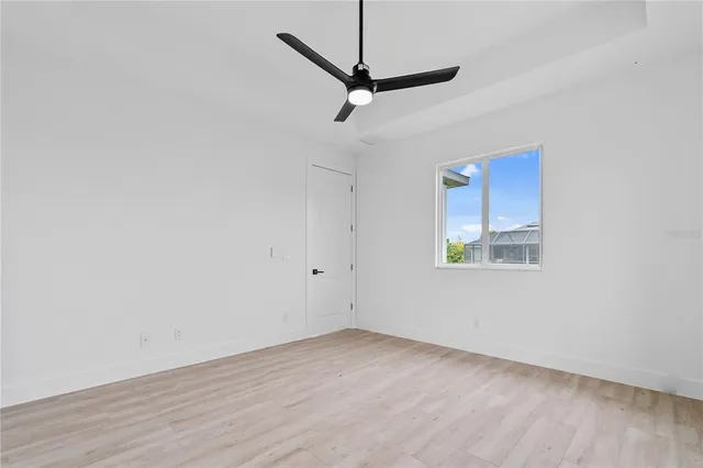 a view of a room with wooden floor and a ceiling fan
