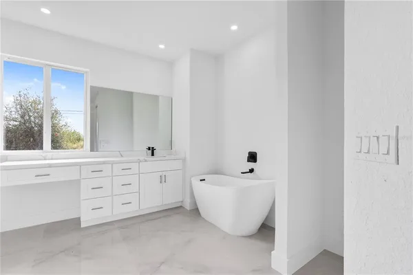 a spacious bathroom with a double vanity sink a mirror and a bathtub