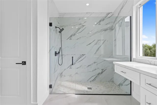 a bathroom with a granite countertop shower a sink and a mirror