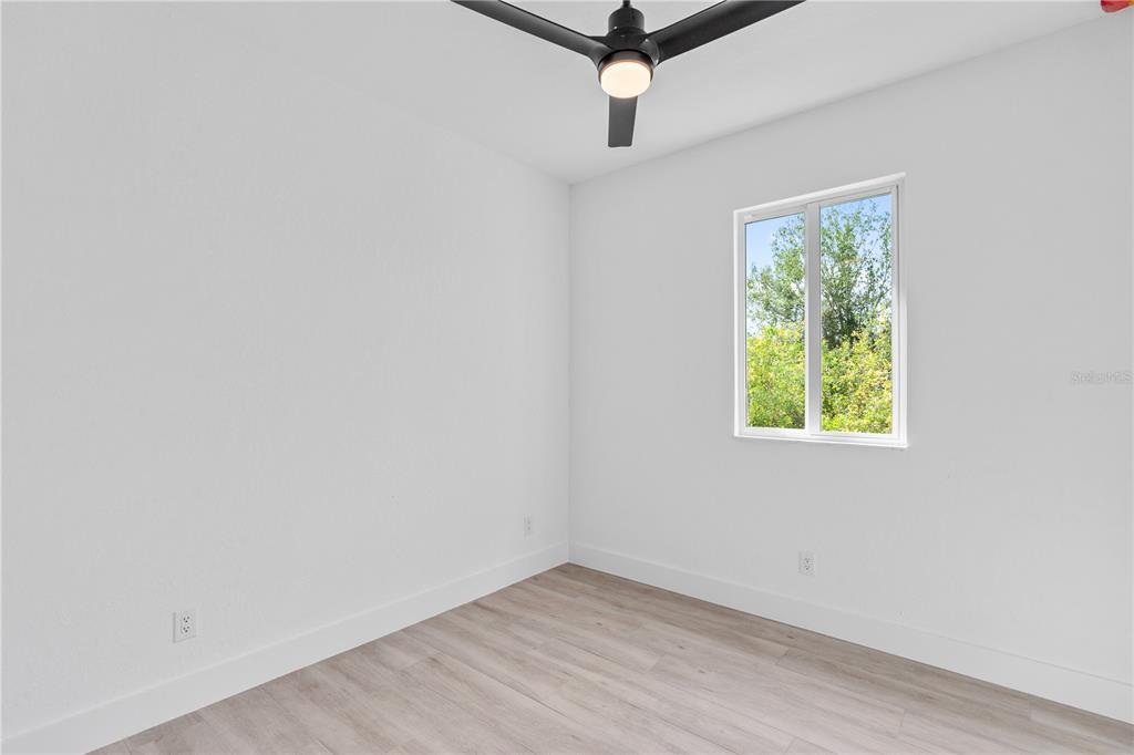 13438 Mc Intosh Avenue Port Charlotte, FL 33981 - Photo 35 of 46 an empty room with a window and a ceiling fan
