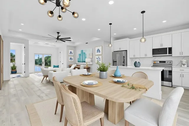 a view of a dining room with furniture a kitchen and chandelier