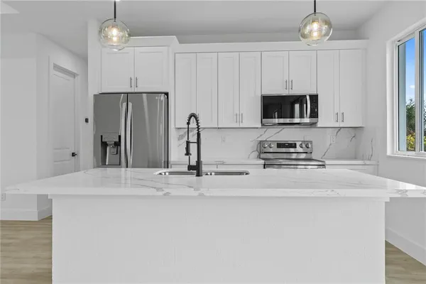 a kitchen with stainless steel appliances a stove refrigerator and cabinets