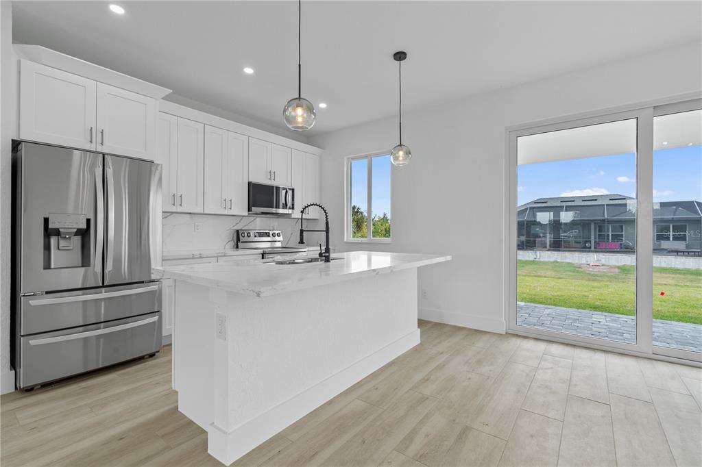13438 Mc Intosh Avenue Port Charlotte, FL 33981 - Photo 10 of 46 a kitchen with kitchen island a counter top space stainless steel appliances and a window