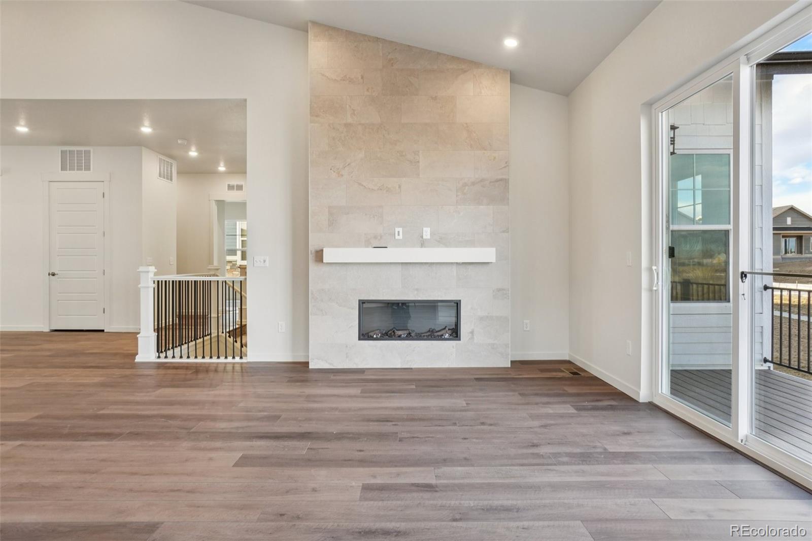 1726 Morningstar Way Fort Collins, CO 80524 - Photo 10 of 50 a view of an empty room with wooden floor and a fireplace