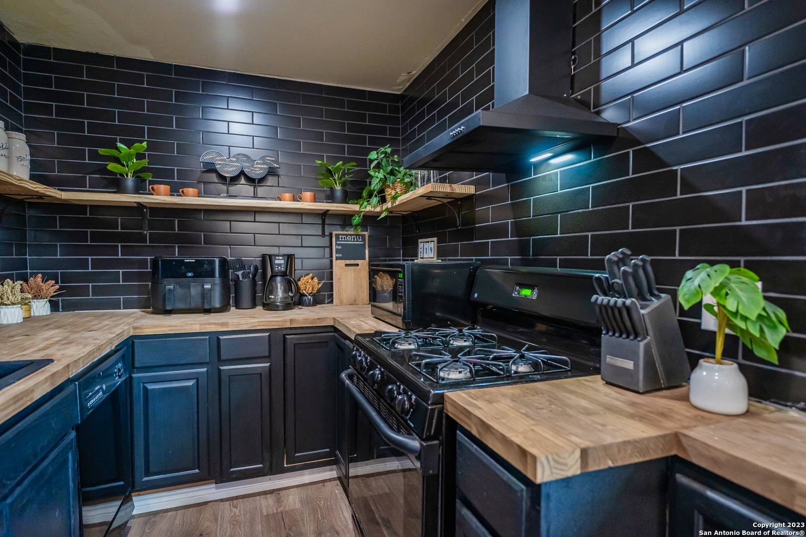 a kitchen with stainless steel appliances granite countertop a sink a stove and wooden cabinets