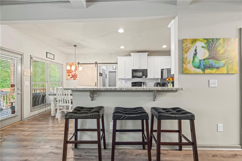 816 Mimosa Way Jefferson, GA 30549 - Photo 21 of 83 a kitchen with stainless steel appliances granite countertop a table chairs microwave and sink