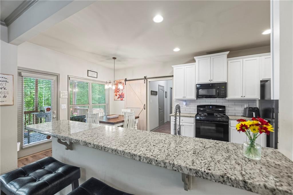 816 Mimosa Way Jefferson, GA 30549 - Photo 22 of 83 a kitchen with stainless steel appliances granite countertop sink stove top oven and refrigerator
