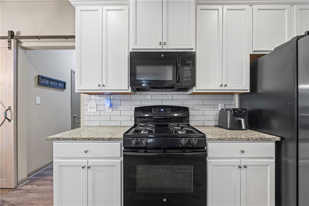 816 Mimosa Way Jefferson, GA 30549 - Photo 23 of 83 a kitchen with granite countertop white cabinets and stainless steel appliances