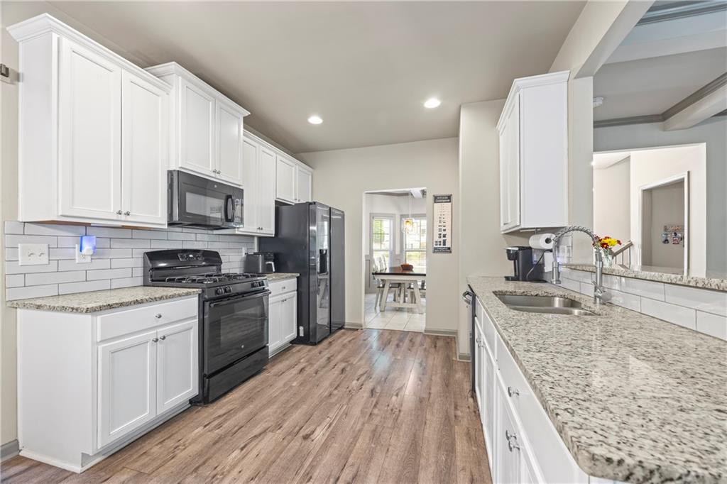 816 Mimosa Way Jefferson, GA 30549 - Photo 24 of 83 a kitchen with stainless steel appliances granite countertop a stove top oven a sink dishwasher a refrigerator and cabinets with wooden floor
