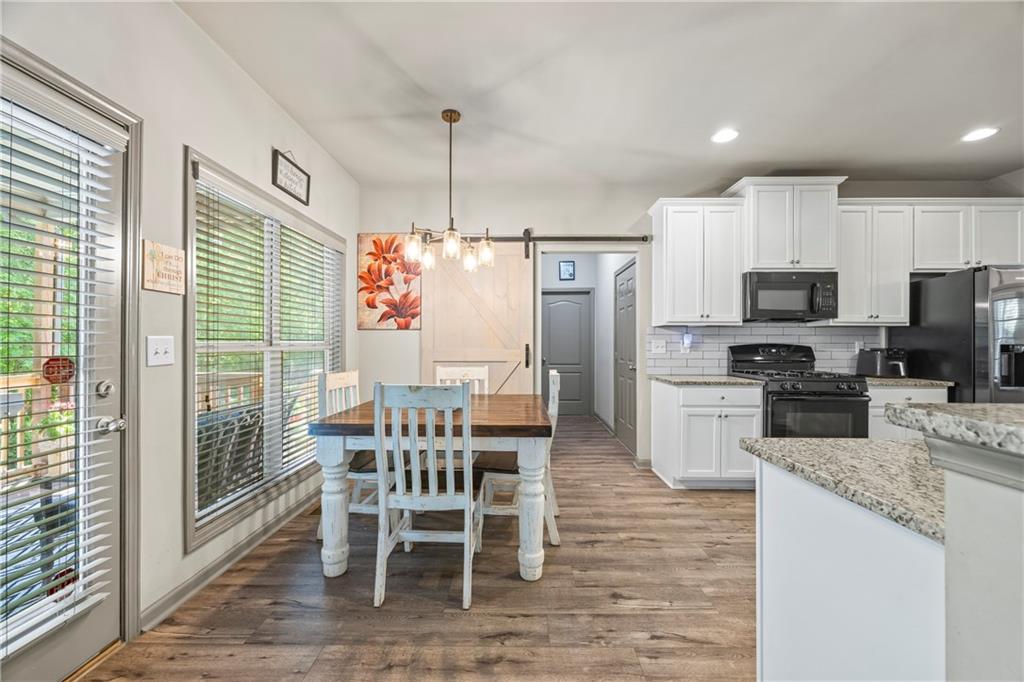 816 Mimosa Way Jefferson, GA 30549 - Photo 27 of 83 a kitchen with stainless steel appliances granite countertop a refrigerator a stove top oven a sink with granite countertop a dining table and chairs