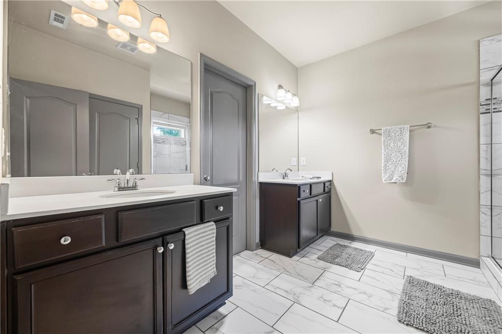 816 Mimosa Way Jefferson, GA 30549 - Photo 60 of 83 a spacious bathroom with a granite countertop sink a mirror and a shower