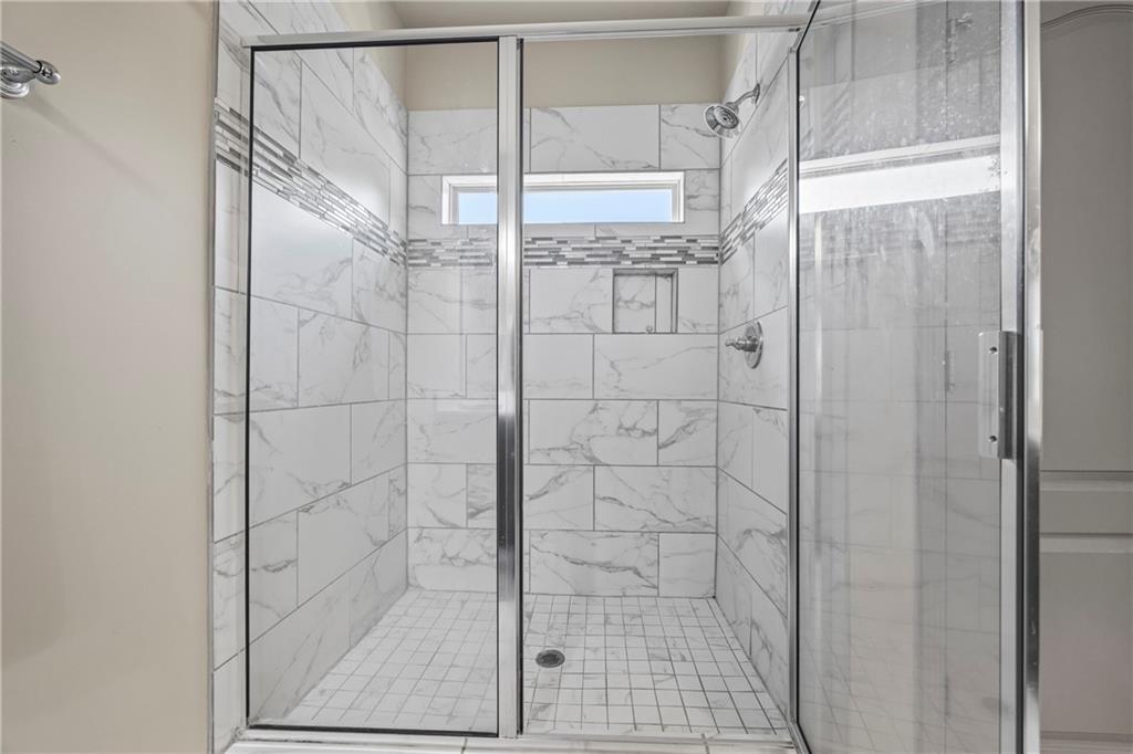 816 Mimosa Way Jefferson, GA 30549 - Photo 65 of 83 a bathroom with a glass shower door