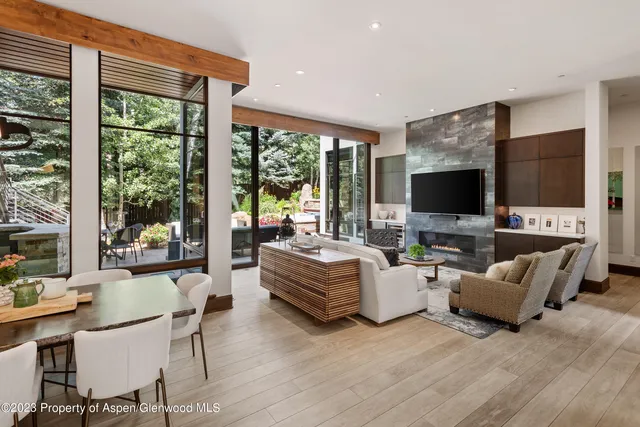 a living room with furniture a flat screen tv and a floor to ceiling window