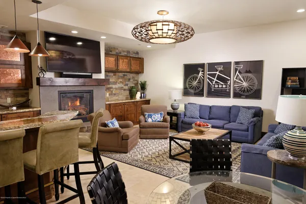 a living room with furniture a flat screen tv and kitchen view