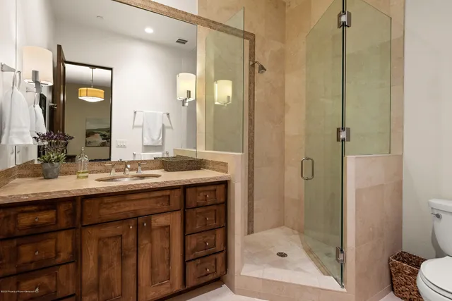 a bathroom with a shower sink and mirror