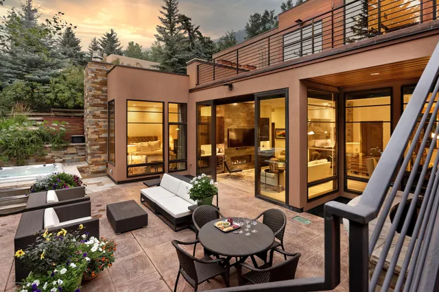 a view of a patio with couches table and chairs and potted plants
