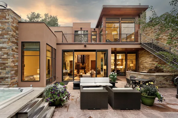 a view of a patio with couches table and chairs and potted plants
