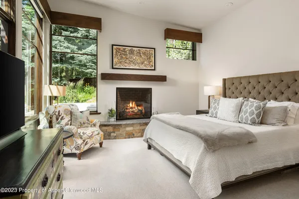 a bedroom with a bed couch tv and window