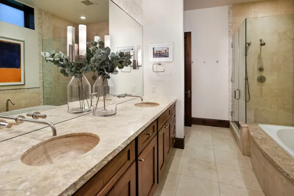 a bathroom with a granite countertop sink a large mirror and a bathtub