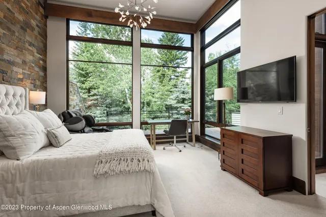 a bedroom with a large bed and a flat tv screen on dresser