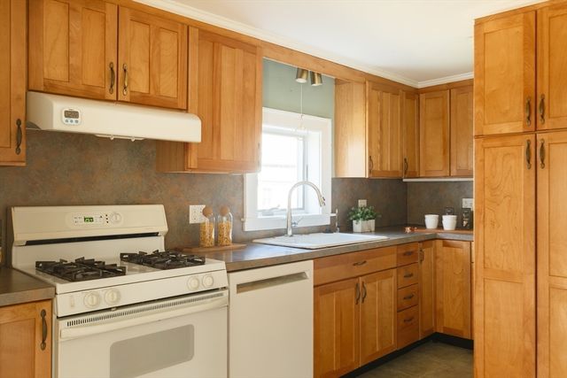 a kitchen with appliances a sink and cabinets
