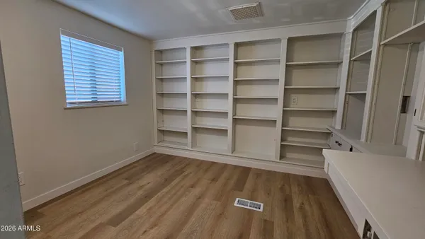 a view of a room with wooden floor and a window