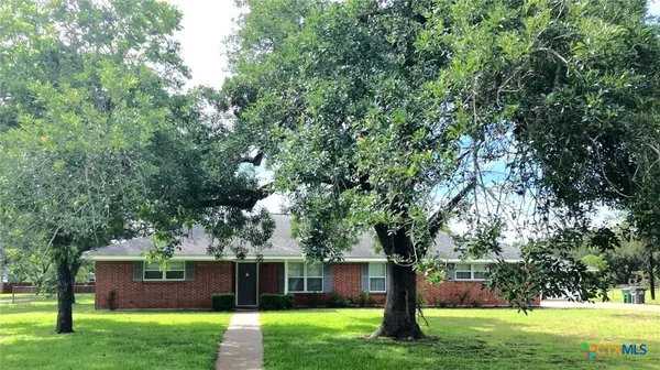 a view of a house with backyard and a tree