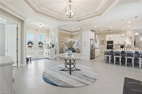 a living room with furniture a dining table and a chandelier