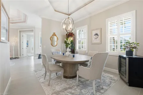 a dining room with furniture a chandelier and wooden floor