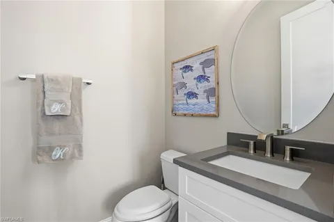 a bathroom with a granite countertop sink mirror vanity and toilet