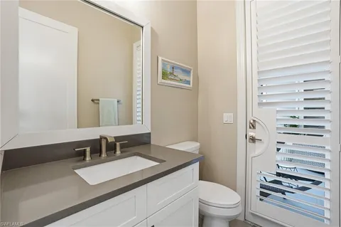 a bathroom with a toilet a sink and mirror