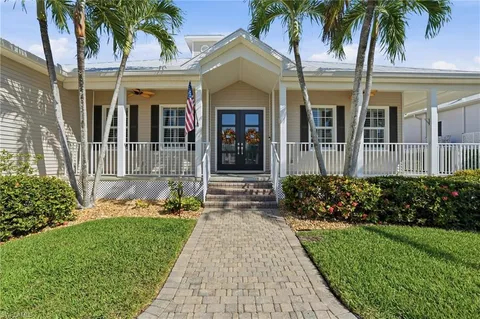 front view of a house with a yard and potted plants