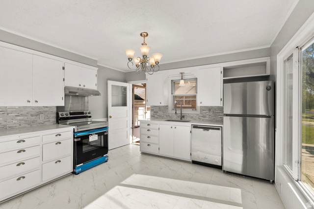 658 North 100 East Logan, UT 84321 - Photo 7 of 26 Kitchen featuring white cabinetry, light-toned countertops, and a mosaic tile backsplash