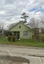 a view of a house next to a yard with brick walls
