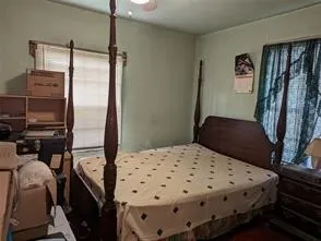a bedroom with a bed and a flat tv screen on the dresser