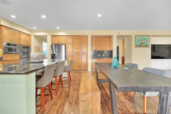 a living room with lots of furniture wooden floor and a large window
