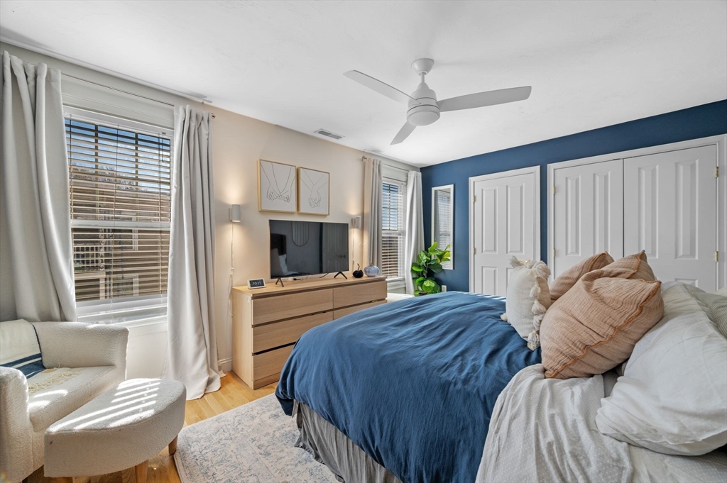 133 Eastern Avenue, Unit 8 Lynn, MA 01902 - Photo 25 of 38 a bedroom with a bed a couch and a flat tv screen