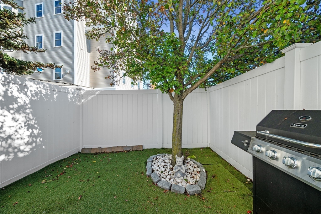 133 Eastern Avenue, Unit 8 Lynn, MA 01902 - Photo 32 of 38 a backyard of a house with lots of green space