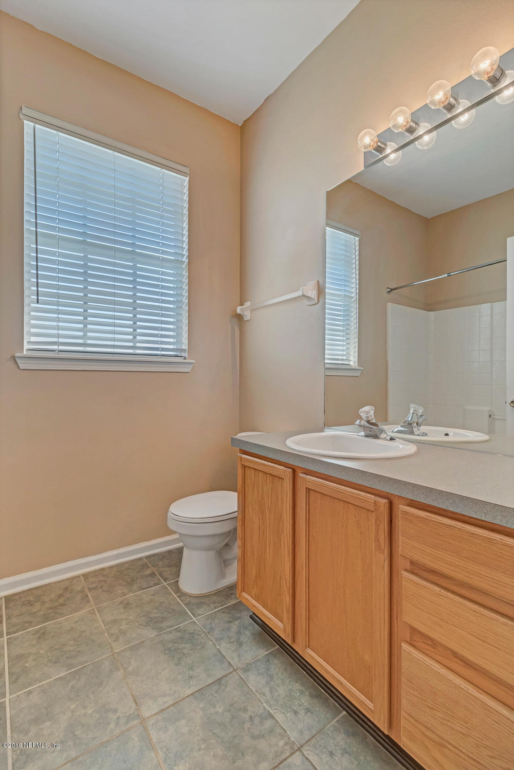 7990 Baymeadows Road East, Unit 211 Jacksonville, FL 32256 - Photo 14 of 21 a bathroom with a granite countertop sink a toilet and a mirror