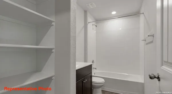 a bathroom with a bathtub shower sink vanity and toilet