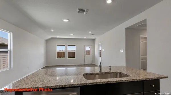 a kitchen with granite countertop sink and mirror