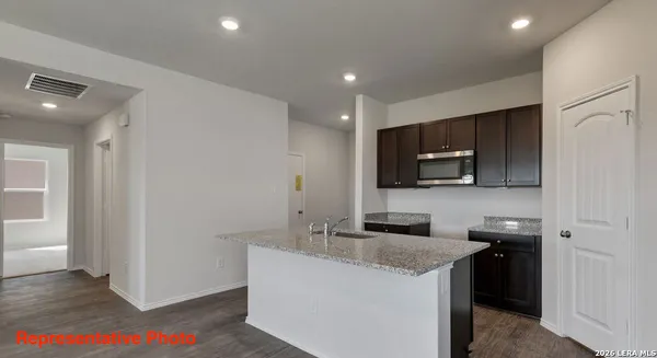 a kitchen with granite countertop a sink and a stove top oven