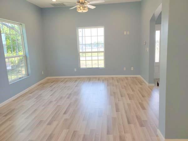209 Campus Street Ferris, TX 75125 - Photo 19 of 33 an empty room with wooden floor and windows