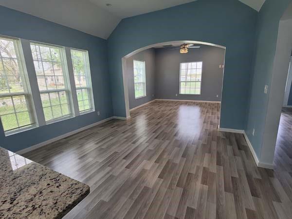 209 Campus Street Ferris, TX 75125 - Photo 4 of 33 an empty room with wooden floor and windows