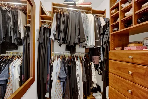 a view of walk in closet with clothes and shoes