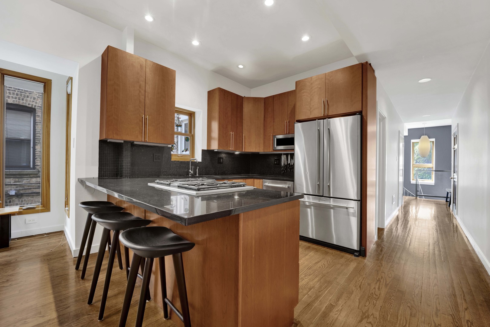 634 West Grace Street, Unit 1E Chicago, IL 60613 - Photo 6 of 26 a kitchen with stainless steel appliances granite countertop a refrigerator a stove a sink dishwasher and a stove with wooden floor